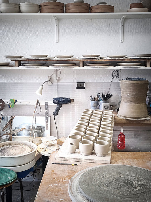 Atelier de poterie avec céramiques artisanales en cours de fabrication.
